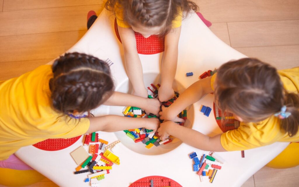 Niños jugando con bloques de construcción en una mesa
