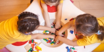 Niños jugando con bloques de construcción en una mesa