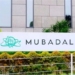 Logo de Mubadala en su sede con vegetación alrededor