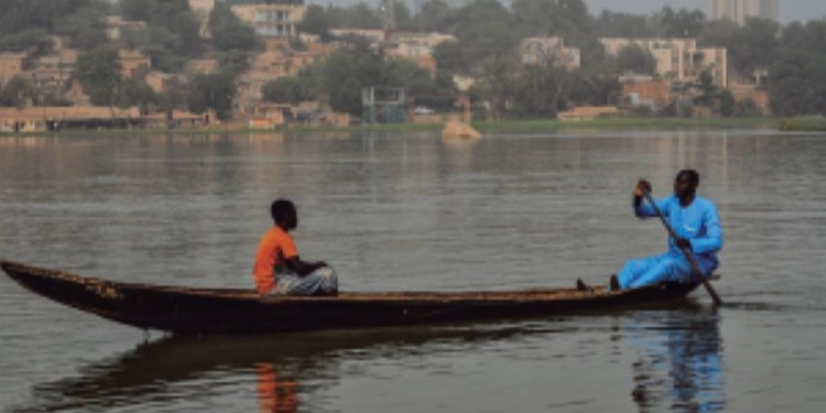 Un niño y un hombre en una piragua en el río Níger