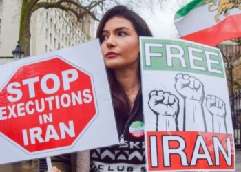 Mujer sosteniendo carteles en protesta contra las ejecuciones en Irán