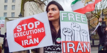 Mujer sosteniendo carteles en protesta contra las ejecuciones en Irán