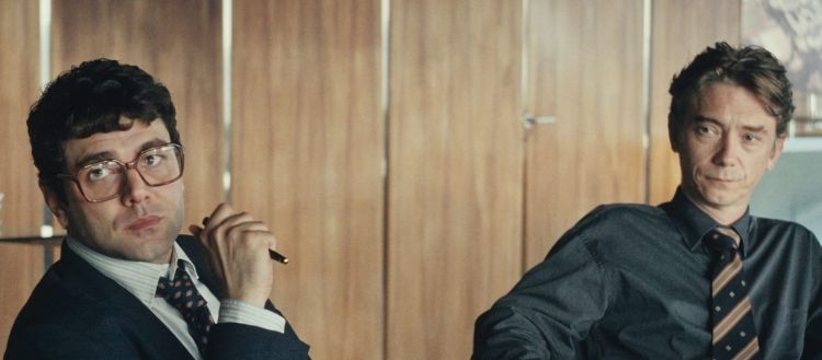 Escena de la película El Arquitecto con dos personajes en una reunión