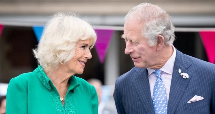 El rey Carlos III y la reina Camila sonriendo en un evento público.