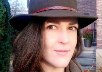 Retrato de Alicia Cocero con sombrero en un entorno urbano.